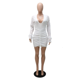 Detail of white sequin dress with deep V-neck, ruched center and feather cuffs
