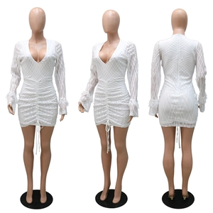 Detail of white sequin dress with deep V-neck, pleated texture, and feather cuffs