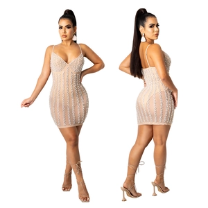 Detail of a beige mesh mini dress featuring vertical faux pearl beads and thin straps
