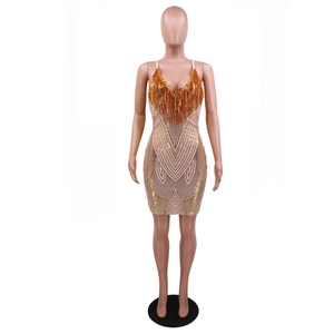 Detailed view of sequins and orange-gold fringe tassels on a party dress v-neckline