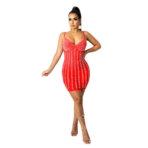 Detail of red bodycon mini dress featuring intricate white pearl beading and V-neckline