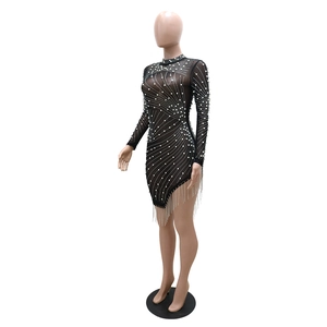 Détail d'une robe en résille noire avec perles blanches et longues franges argentées