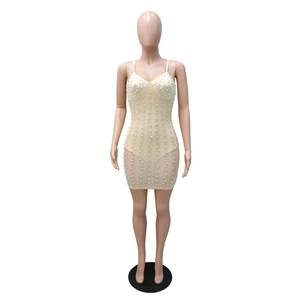 Detail of nude mesh mini dress featuring intricate white pearls and rhinestone embellishments