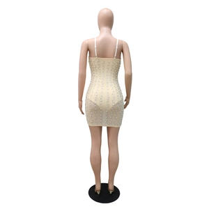 Detailed back view of a champagne mini dress with white pearls and thin straps