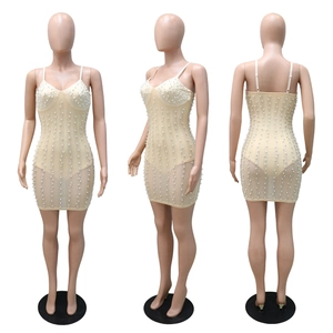 Detail view of bodycon mini dress with rhinestones and faux pearls on mesh fabric