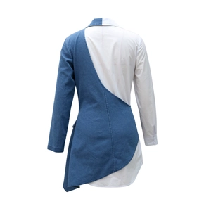 Detail of asymmetrical stitching and blue denim patchwork on the white dress back