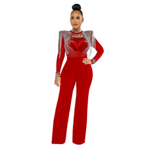 Détails des franges argentées et des motifs en strass sur une combinaison rouge chic
