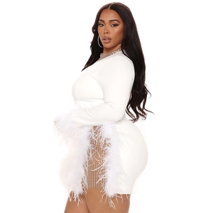 Detail of white bodycon dress featuring rhinestone mesh cutouts and luxury feather trim