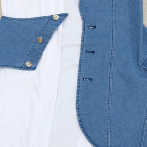 Detail of denim v-neck dress with metal buttons and classic shirt collar overlap