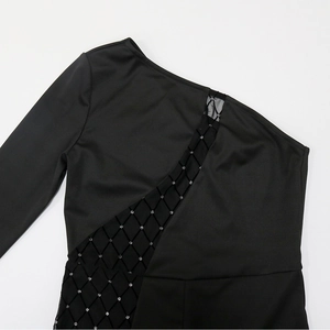 Detail of one-shoulder black top with diagonal mesh cutout and rhinestone diamond pattern