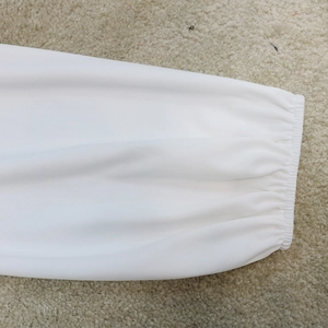 Detailed close-up of white dress sleeve showing elastic cuffs and pleated fabric texture