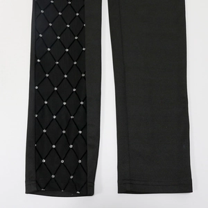Detail of black leggings featuring sheer mesh paneling with shimmering silver glitter accents
