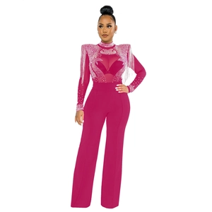 Combinaison en maille rose rouge avec strass brillants, franges aux épaules et pantalon évasé