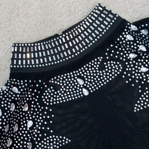 Détail d'une robe en tulle à col montant ornée de strass brillants et de motifs en cristal