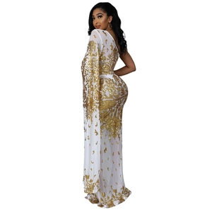Detail of white slim fit one-shoulder dress with elegant gold sequins and cape sleeve