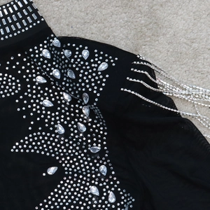 Détails de robe de soirée noire avec paillettes argentées et franges à strass brillantes