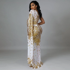 Detail of white mesh dress featuring gold sequins and asymmetrical one-shoulder sleeve