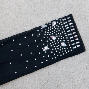 Détail de strass argentés étincelants et de pompons sur le tissu en tulle noir de la robe
