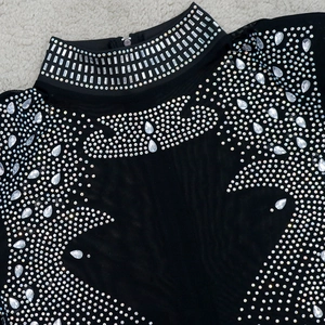 Détails de strass scintillants et franges sur le col d'un body en maille transparente