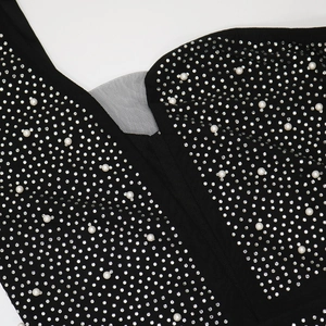 Macro detail of sexy evening dress showing rhinestones, pearls, and mesh V-neckline