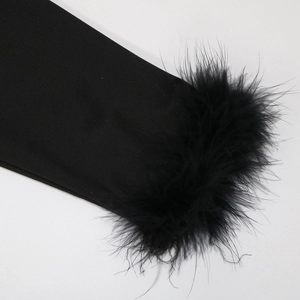 Detail of luxury dress featuring lush black feather trim on premium glossy fabric