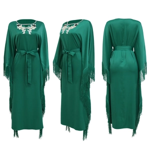 Three-way view of emerald green satin kaftan featuring white floral embroidery and long tassels