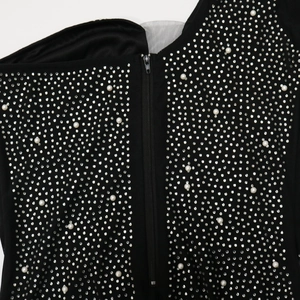 Detail of black dress featuring silver rhinestones, faux pearls and a sturdy metal zipper
