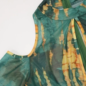 Detail of sheer mesh fabric with green tie-dye pattern and zipper on turtleneck