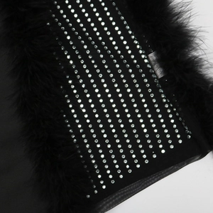 Macro detail of black feather trim and sparkling rhinestones on the cotton fabric dress