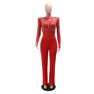 Détail de la combinaison en mesh rouge avec motifs strass et franges sur les épaules