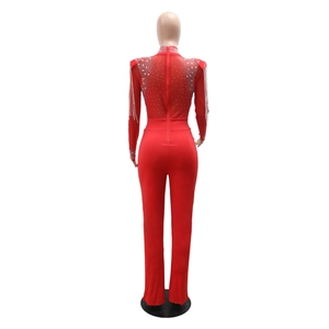 Détail d'un body en mesh rouge avec strass, épaules à franges et fermeture éclair