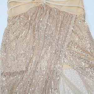 Detailed macro view of champagne gold sequins on a mesh party dress with thin straps