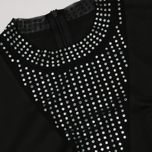 Detail of neckline with rhinestones, polka dot mesh trim and back zipper on black dress