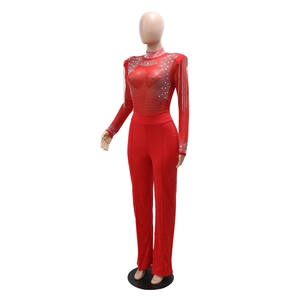 Détail d'un body en maille rouge avec strass argentés et glands à franges aux épaules
