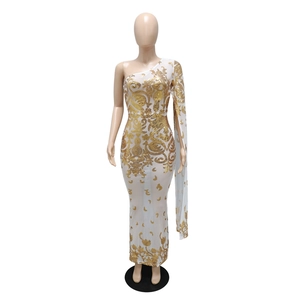 Close-up of gold sequin embroidery and baroque patterns on a white one-shoulder dress