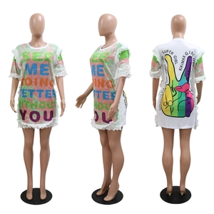Detail of white velvet sequin dress featuring colorful lettering and ruffled hemline