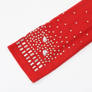 Détail de maille rouge avec strass argentés et cristaux en forme de larme étincelants