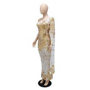 Detail of white mesh evening gown with gold baroque sequins and one-shoulder cape sleeve