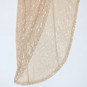 Macro detail of champagne gold sequin dress showing side slit and vertical stripes