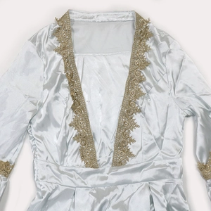 Detail of light blue satin dress featuring gold lace embroidery on the neckline and cuffs