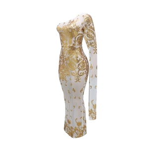 Close-up of golden sequin baroque patterns on white sheer one-shoulder evening dress