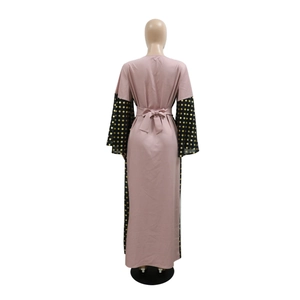 Detail of flared sleeves with gold polka dots and a waist bow on a pink Abaya dress