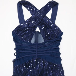 Detail of navy blue sequin dress with cross halter neck and sheer mesh panels