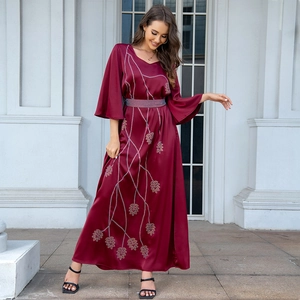 Detail of burgundy satin gown featuring rhinestone leaf pattern and flared sleeves