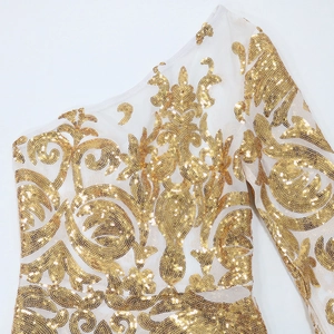 Detail of white mesh dress with intricate gold sequin embroidery and baroque patterns