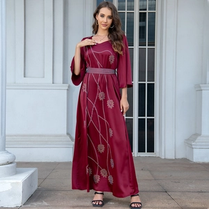 Detail of burgundy satin dress featuring gold leaf patterns and a sparkling rhinestone belt