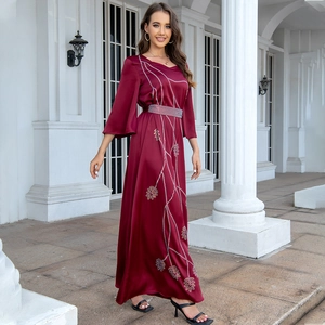 Detail of leaf pattern silver embroidery on elegant wine red satin formal gown