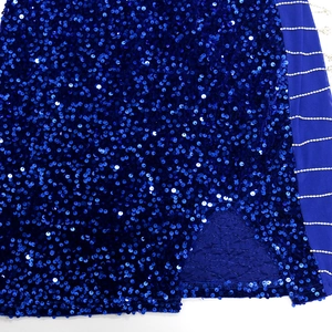 Detail of royal blue sequin dress with slit and shimmering rhinestone chain trim