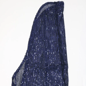 Close-up of sparkling dark blue sequins on transparent mesh fabric with vertical stripes