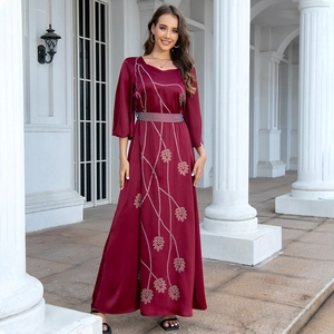 Detail of burgundy gown featuring golden sequin leaf patterns and matching waist belt